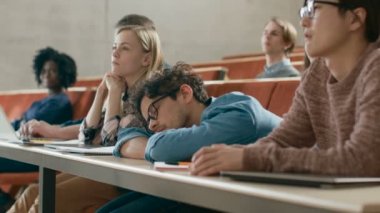 Üniversitesi'nde ders hakkında yorgun erkek öğrenci uyur. Çok yorgun ve çok çalışan genç erkek.