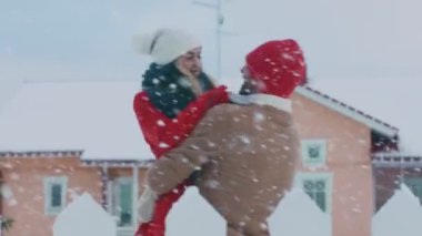 Güzel genç çift dans ve Spin - kar sonbahar romantik süre pastoral evlerinin arka bahçesinde sarılmak. Mutlu genç insanlar sihirli kış zamanında.