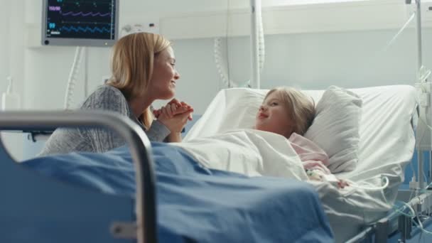 可爱的小女孩躺在儿童医院的床上 她的母亲在旁边 他们说话 现代儿科病房 — 图库视频影像