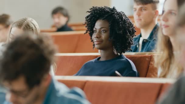聪明美丽的年轻黑人女孩听讲座 在一个教室里充满了多民族学生 浅层景深 — 图库视频影像