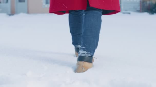 下面是一个女人走在雪上走向她的房子的画面 专注于腿 美丽的白色冬季天气与新鲜的降雪 女人在雪中留下脚印 — 图库视频影像