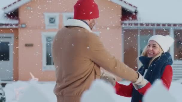 美しい若いカップル ダンスと牧歌的な家の裏庭でスピン中雪秋ロマンチックに 魔法の冬時間の幸せな若者たち — ストック動画