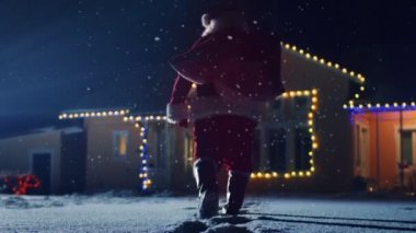 Noel Baba kırmızı çantalı görüntülerini düşük açılı ışıklar ve çelenk ile dekore edilmiş olan pastoral evin ön bahçesine içine yürüyor. Santa hediyeler ve Presents gece getiriyor. Büyülü New Year's Eve düşen kar.