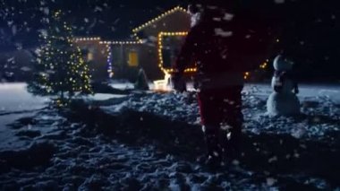 Noel Baba kırmızı çantalı görüntülerini düşük açılı ışıklar ve çelenk ile dekore edilmiş olan pastoral evin ön bahçesine içine yürüyor. Santa hediyeler ve Presents gece getiriyor. Büyülü New Year's Eve düşen kar.