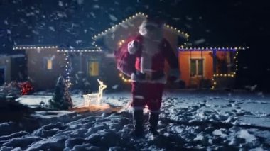 Noel Baba kırmızı çantalı görüntülerini düşük açılı ışıklar ve çelenk ile dekore edilmiş olan pastoral evin ön bahçesine içine yürüyor. Santa hediyeler ve Presents gece getiriyor. Büyülü New Year's Eve düşen kar.