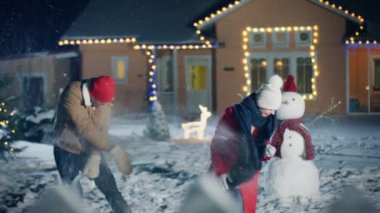 Genç güzel çift onların güzel ev içinde belgili tanımlık geçmiş ile kartopu atın, her şeyi Noel arifesi için ışıkları ve çelenk ile süslüdür. Erkek ve kadın aşık. Aile bir kış akşam düşen kar ile.