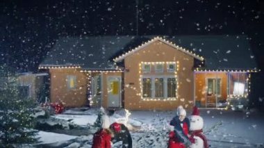 Mutlu kış akşam genç baba üzerinde kartopu, kardan adam çalışan anne ve sevimli küçük kız oynar. Babası kucaklayan her ikisi de karısı ve kızı. Çelenk ile pastoral evlerini dekore edilmiş arka.