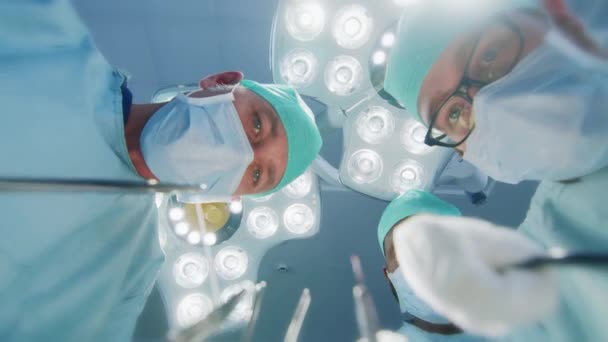 Low Angle Shot POV Patient View: Three Professional Surgeons Holding Surgical Instruments Starting Surgery. — Stock Video