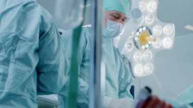 Ameliyathanede Düşük Açı Atışı, İstilacı Ameliyat sırasında Baş Cerraha Asistan Geçiş Aletini Verdi. Modern Hastanesi 'nde Profesyonel Doktorlar Ameliyat Yapıyor.