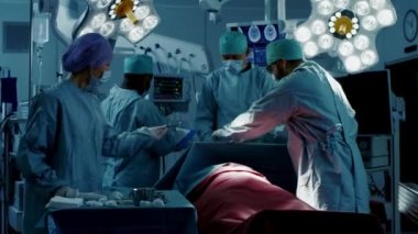 Hastane Ameliyathanesinde Bir Hastaya İnvaziv Cerrahi Yapan Çeşitli Profesyonel Cerrahlar Ekibi. Hemşire Hands Out Aletleri cerraha, Anestezi uzmanı Vitals izler. Gerçek Modern Hastane.