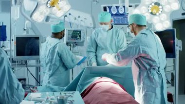 Muhtelif profesyonel cerrah ekipleri, asistanlar ve hemşireler bir hastayı ameliyat odasında ameliyat ediyorlar. Otantik Ekipmanlı Gerçek Modern Hastane.