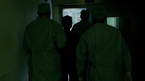 Après le tournage d'une équipe diversifiée de chirurgiens et d'assistants qui entrent dans la salle d'opération où le patient attend, ils le placent sous anesthésie et commencent la chirurgie. Véritable hôpital moderne avec équipement authentique . — Video