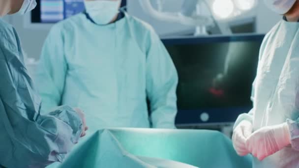 Крупный план в операционной Помощник раздает инструменты хирургам во время операции. Операция в процессе. Профессиональные врачи-хирурги . — стоковое видео