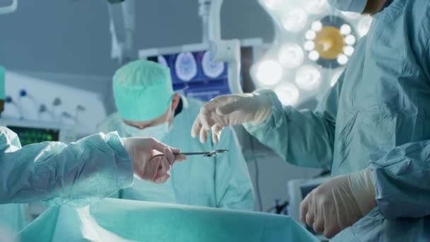 Közelkép a műtőben, asszisztens kiadja a műszereket a sebészeknek a műtét alatt. Műtét folyamatban van. Szakmai Orvosok Végző Sebészet. — Stock videók
