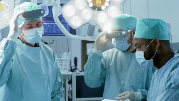 Chirurgen zetten Augmented Reality Glasses op om state of the art chirurgie uit te voeren in het High Tech ziekenhuis. Artsen en assistenten werkzaam in de operatiekamer. — Stockvideo