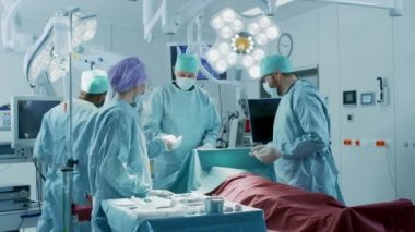 Hastane Ameliyathanesinde Bir Hastaya İnvaziv Cerrahi Yapan Profesyonel Cerrah, Asistan ve Hemşirelerden Oluşan Çeşitli Ekip. Cerrahlar Konuşma ve Kullanım Aletleri. Otantik Ekipman ile Gerçek Modern Hastane.