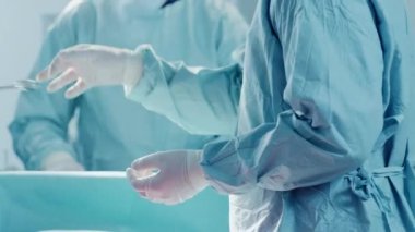 Ameliyat Asistanında Yakın Çekim Ameliyat Sırasında Cerraha Aletleri Teslim Eder. Ameliyat devam ediyor. Cerrahi Yapan Profesyonel Tıp Doktorları.