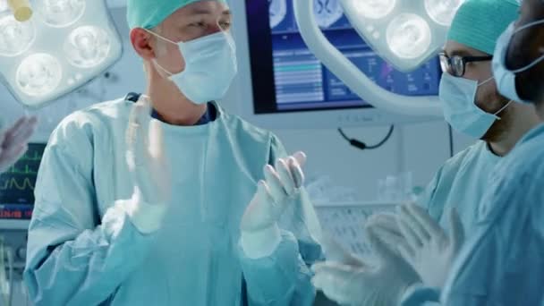Dans la salle d'opération de l'hôpital Une équipe diversifiée de chirurgiens et d'adjoints professionnels s'attend à ce que la chirurgie et les applaudissements soient terminés. Médecins professionnels célébrant la vie sauvée avec succès. — Video