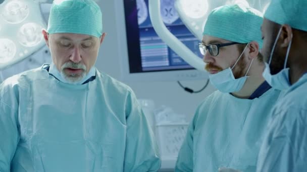 Sokszínű csapata a szakmai sebész, asszisztensek és az ápolók végző invazív sebészet a beteg a kórházban műtőben. Sebészek aktív vita próbálják megmenteni az élet egy beteg. — Stock videók