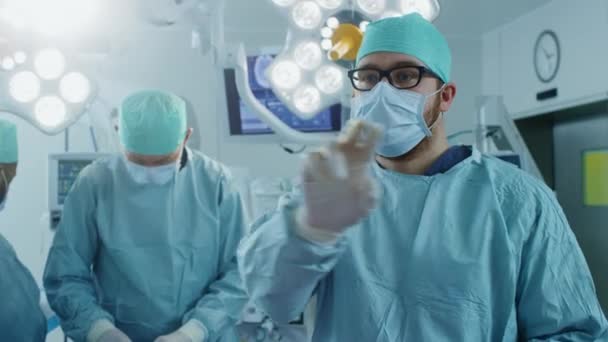 V operačním sále chirurgové gesta pomocí technologie rozšířené reality během operace. In the background Assistants and Nurses Working with Real Equipment.