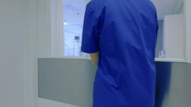 No Hospital, a enfermeira entra na enfermaria médica e faz o check-up de um paciente deitado na cama. Hospital moderno limpo com funcionários amigáveis e profissionais . — Vídeo de Stock