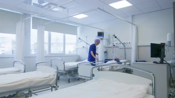 Dans l'hôpital Medical Ward Nurse prend soin d'un patient allongé au lit. Hôpital moderne propre avec personnel amical et professionnel. — Video