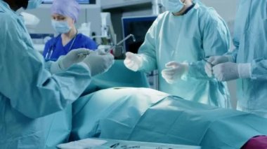 Muhtelif Profesyonel Cerrahlar Ekibi Hastane Ameliyathanesinde Bir Hastaya İstilacı Ameliyat Yapıyor. Cerrahlar ve diğer araçları kullanır.