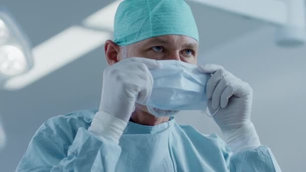 Portret van de professionele chirurg zetten op chirurgische masker in de achtergrond Moderne ziekenhuis Operating Room. — Stockvideo