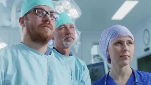 Скользящий снимок команды профессиональных хирургов, ассистентов и медсестер, гордо стоящих в настоящей современной больнице с аутентичным оборудованием . — стоковое видео