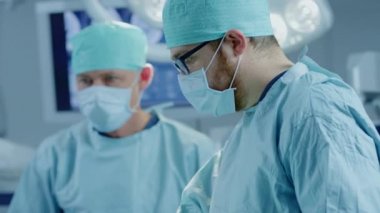 Hastane Ameliyathanesinde Bir Hastaya İnvaziv Cerrahi Yapan Profesyonel Cerrah, Asistan ve Hemşirelerden Oluşan Çeşitli Ekip. Cerrahlar Konuşma ve Kullanım Aletleri. Otantik Ekipman ile Gerçek Modern Hastane.