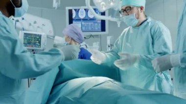 Muhtelif Profesyonel Cerrahlar Ekibi Hastane Ameliyathanesinde Bir Hastaya İstilacı Ameliyat Yapıyor. Cerrahlar ve diğer araçları kullanır.