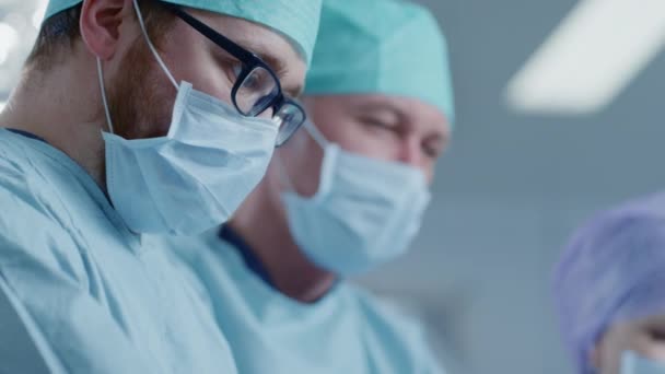Στο χειρουργείο δύο χειρουργοί κατά τη διάρκεια της χειρουργικής επέμβασης. Επαγγελματίες γιατροί στο σύγχρονο νοσοκομείο. — Αρχείο Βίντεο