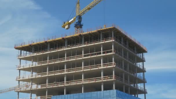 Aerial Orbit Shot of the Skyscraper being Build in the Business District (en inglés). En el fondo Grúas y cielo azul . — Vídeo de stock