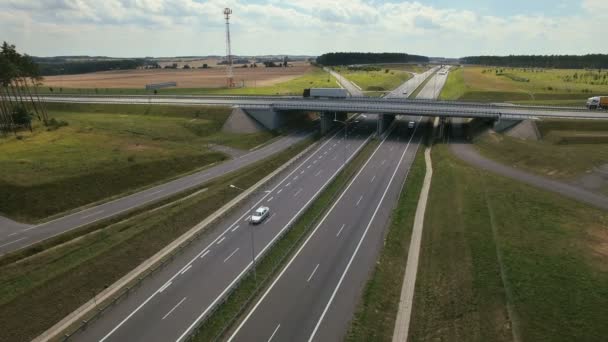 Vista aerea dei semirimorchi bianchi che passano il cavalcavia occupato dell'autostrada / overdrive / ponte . — Video Stock