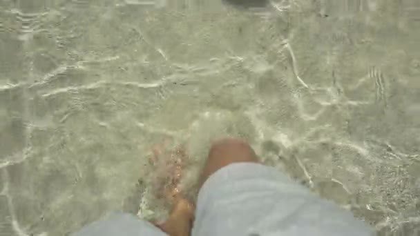 Benen wandelen door een ondiep zand water. — Stockvideo