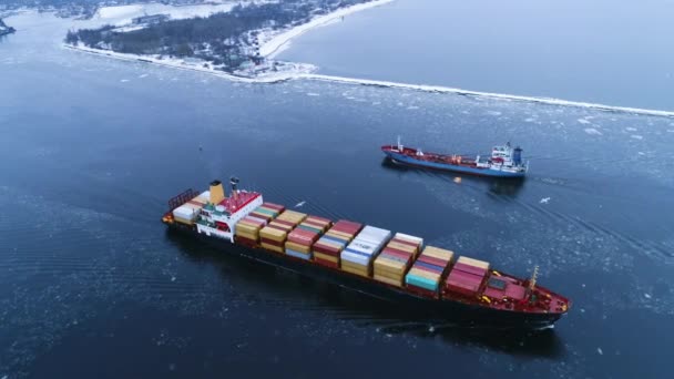 Letecký snímek nákladní lodi pohybující se mořem. V pozadí Zimní krajina. — Stock video