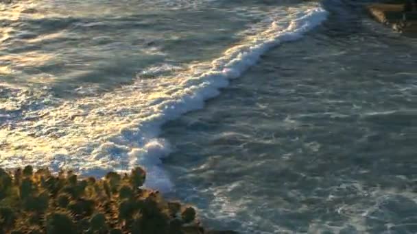 Seguindo o tiro de uma onda oceânica em movimento invadindo a costa rochosa . — Vídeo de Stock