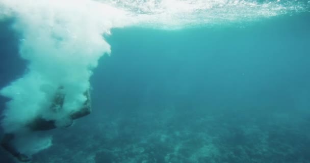 Подводные кадры, где человек прыгает в воду и плавает. Дайвинг на коралловых рифах . — стоковое видео