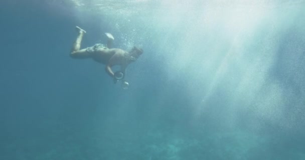 Підводні кадри людини дайвінг в море вивчає коралові рифи і морського життя. Плавання з рибками. — стокове відео