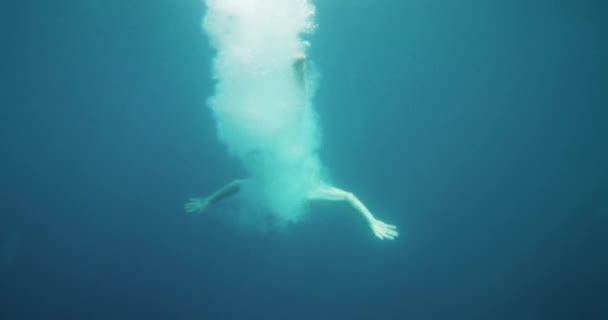 Υποβρύχια πλάνα του ανθρώπου άλμα στο νερό και το κολύμπι. Καταδύσεις στον ωκεανό. — Αρχείο Βίντεο