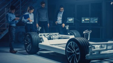 Takım Otomotiv mühendisleri tartışmak ve tasarım elektrikli araba platformu şasi prototip, tedbirler alma, 3D CAD yazılımı ile çalışma, kalite kontrol kontrol. Tekerlekler, motor ve batarya ile araç çerçevesi.