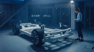Otomobil Mühendisi elektrikli araba şasi platformunda çalışma, 3D CAD yazılım modelleme ile tablet bilgisayar Augmented gerçeklik kullanma. Yenilikçi tesis: tekerlekler, motor, pil ile araç çerçevesi