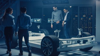 Takım Otomotiv mühendisleri tartışmak ve tasarım elektrikli araba platformu şasi prototip, tedbirler alma, 3D CAD yazılımı ile çalışma, kalite kontrol kontrol. Tekerlekler, motor ve batarya ile araç çerçevesi.