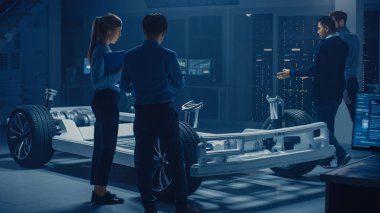 Elektrikli otomobil şasi platformunda çalışan Otomotiv mühendisleri ekibi, önlemler alma, 3D CAD yazılımı ile çalışma, verimliliği analiz etme. Tekerlekler, motor ve batarya ile araç çerçevesi.