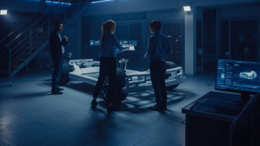 Elektrikli araba platformu şasi prototipi üzerinde çalışan Otomotiv mühendisleri ekibi, önlemler alma, 3B CAD yazılımı ile çalışma, verimliliği analiz etme. Tekerlekler, motor ve batarya ile araç çerçevesi