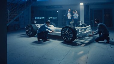 Takım Otomotiv mühendisleri tartışmak ve tasarım elektrikli araba platformu şasi prototip, tedbirler alma, 3D CAD yazılımı ile çalışma, kalite kontrol kontrol. Tekerlekler, motor ve batarya ile araç çerçevesi.