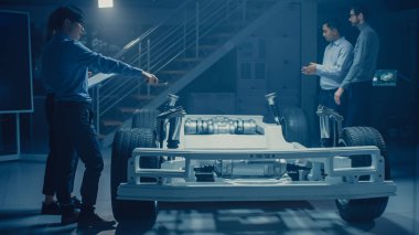 Otomobil mühendisleri elektrikli araba şasi platformu üzerinde çalışan, Uautomobile mühendisleri elektrikli araba şasi platformu üzerinde çalışan, 3D Concept CAD yazılımı ile tablet bilgisayar Augmented gerçeklik kullanma. Otomotiv yenilik tesisi araç çerçevesi w