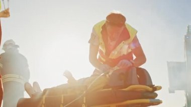 Trafik kazası sahnesinde: Sağlık görevlileri Sedyelerin Üzerinde Yalan Söyleyen Trafik Kazasının Hayatını Kurtarıyor. Kalp atışını dinlerler, oksijen maskesi takarlar ve ilk yardım yaparlar.