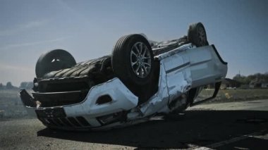 Korkunç trafik kazası, rollover sigara ve yanan araç çarpışma sonrası yolun ortasında çatısında yatıyor. Ağır hasarlı yanan ve sigara araba ile gündüz kaza sahnesi