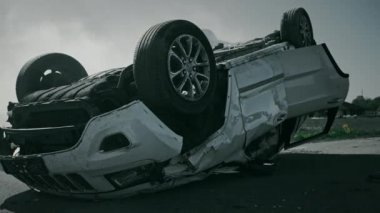 Korkunç trafik kazası rollover sigara ve yanan araç çarpışma sonrası yolun ortasında çatısında yatıyor. Hasarlı araba ile gündüz kaza sahnesi. Siyah ve beyaz yay shot